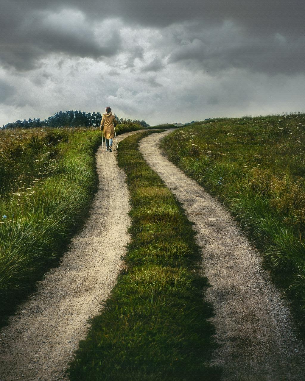 A person walking along a winding path through open countryside